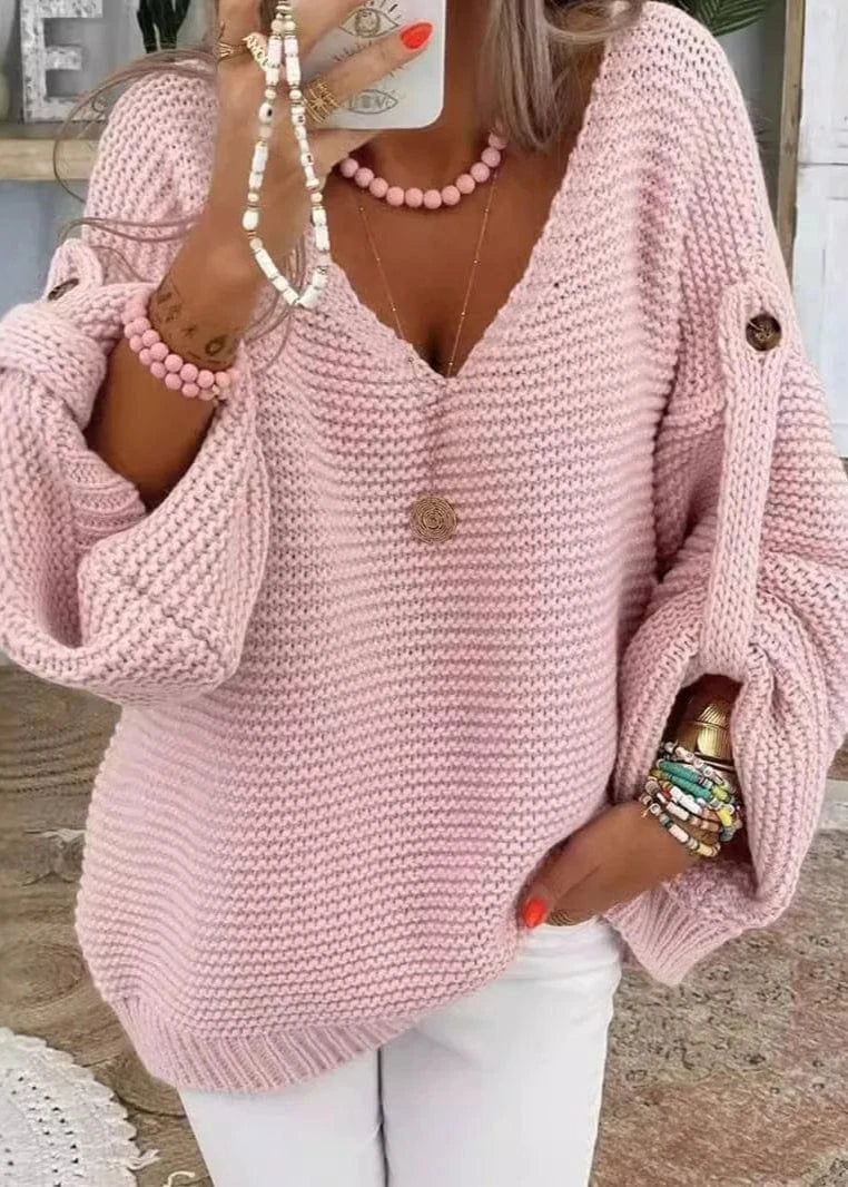 Person wearing a pink knitted sweater with a blurred indoor background