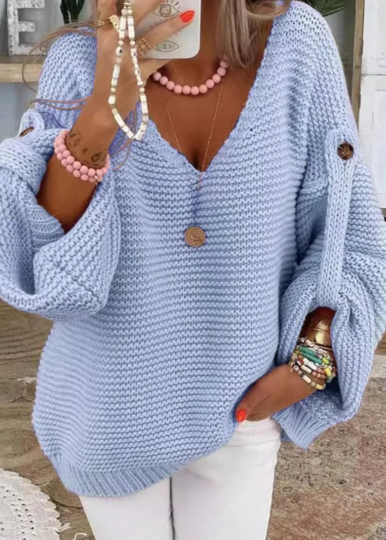 Woman wearing a light blue knitted sweater with a blurred indoor background