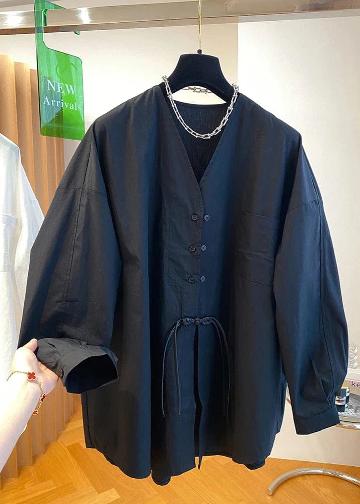 Dark blue jacket with a chain detail on a hanger in a store setting.