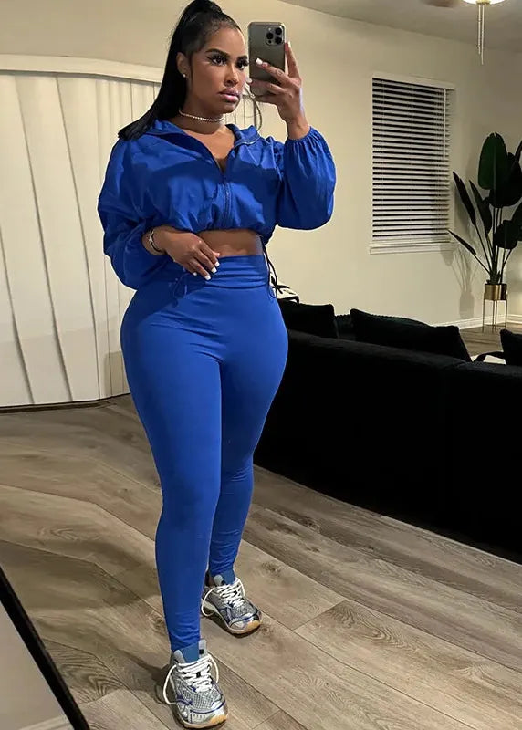 Person taking a mirror selfie wearing a blue outfit in a living room.