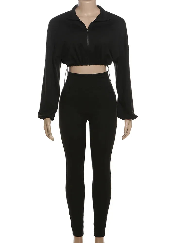 Black long-sleeve top and high-waisted leggings on a mannequin against a white background.