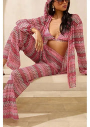 Woman wearing a pink and gray patterned outfit sitting on a wooden floor.