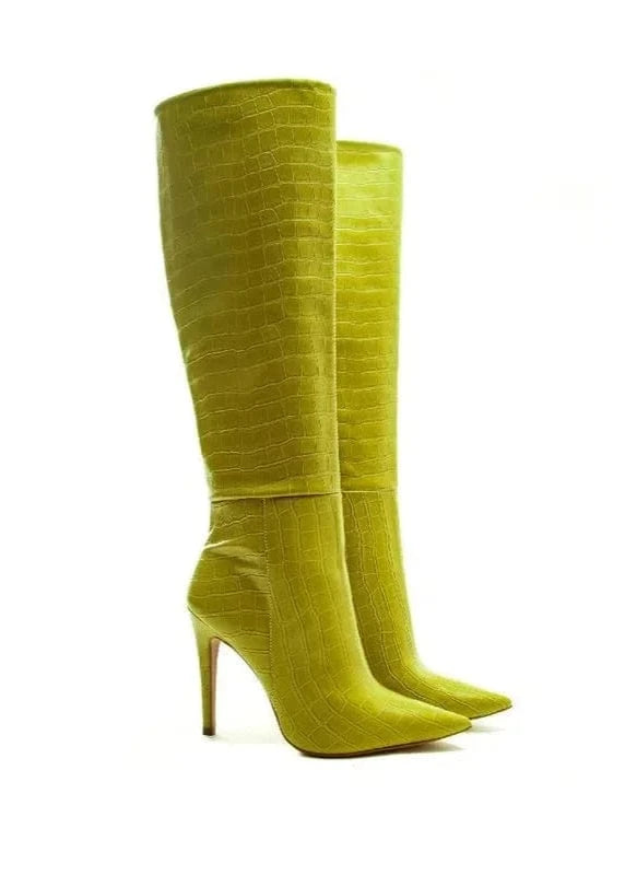 Pair of lime green knee-high boots on a white background