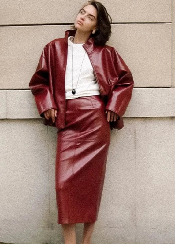 Woman wearing a red leather outfit against a beige wall