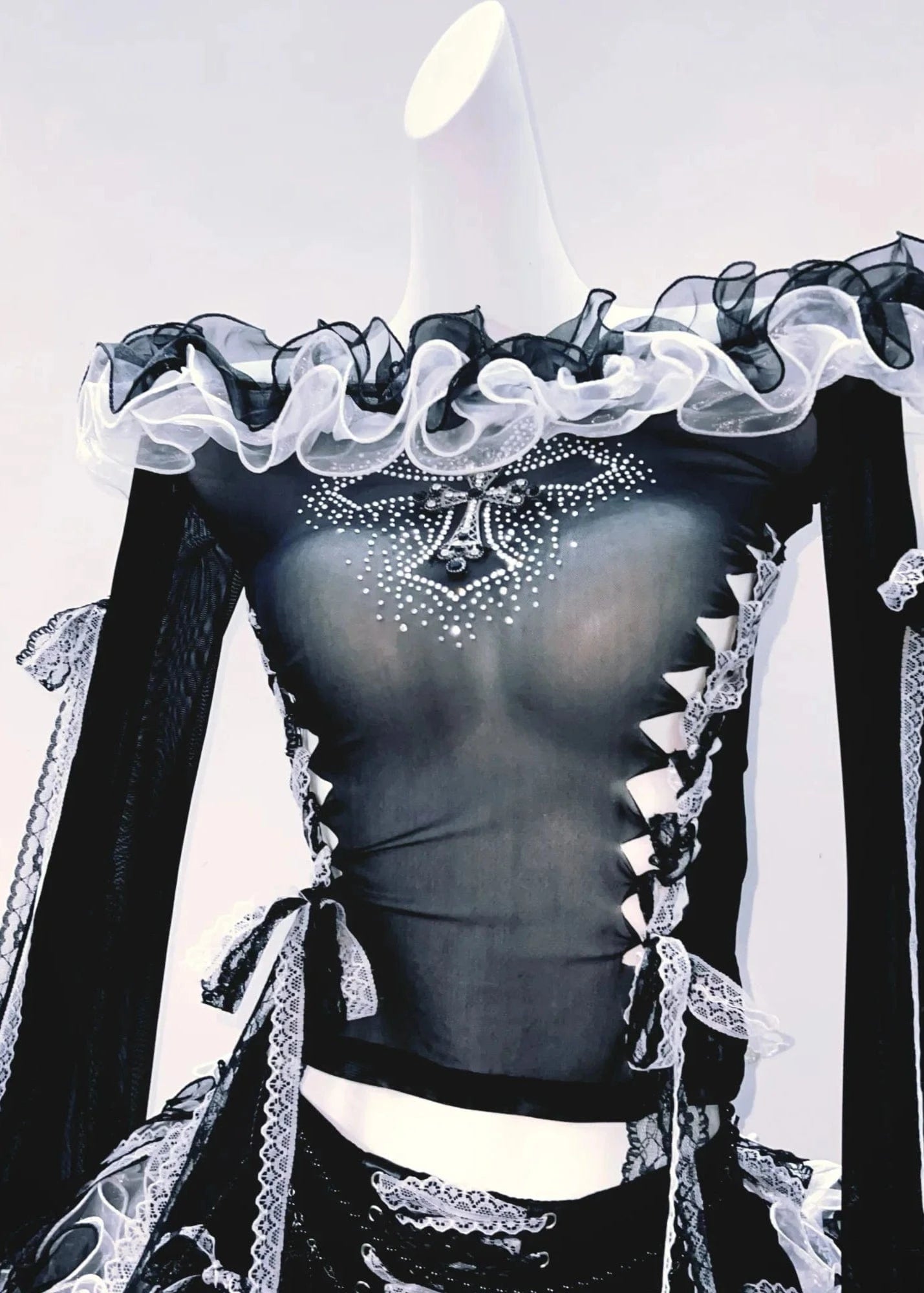 Black and white outfit with ruffled top and long sleeves on a light background