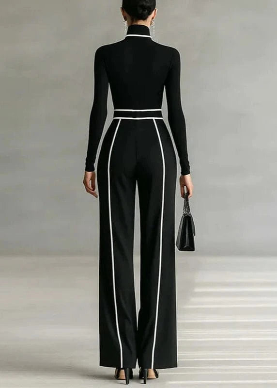 Person wearing a black jumpsuit with white stripes on a neutral background
