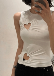 White sleeveless top with heart cutouts worn by a person against a plain background
