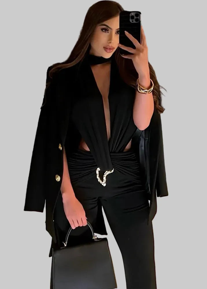 Woman taking a mirror selfie wearing a black outfit with a deep neckline and cut-out details, holding a black handbag.