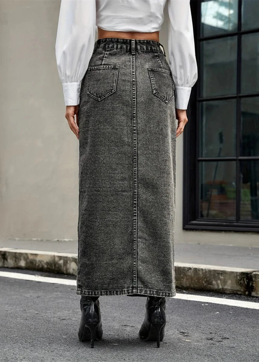 Person wearing a long black denim skirt outdoors.