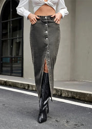Person wearing a white blouse and black denim skirt with high slit outdoors.
