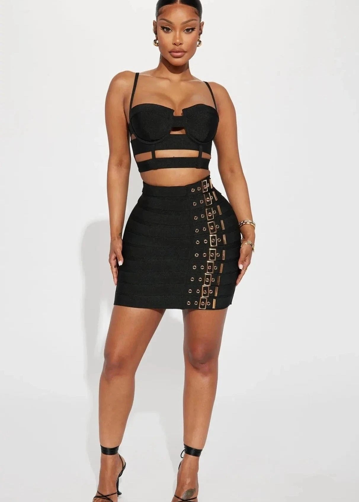Woman wearing a black outfit with cut-out details on a white background