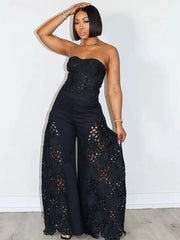 Woman wearing a black lace jumpsuit against a white background
