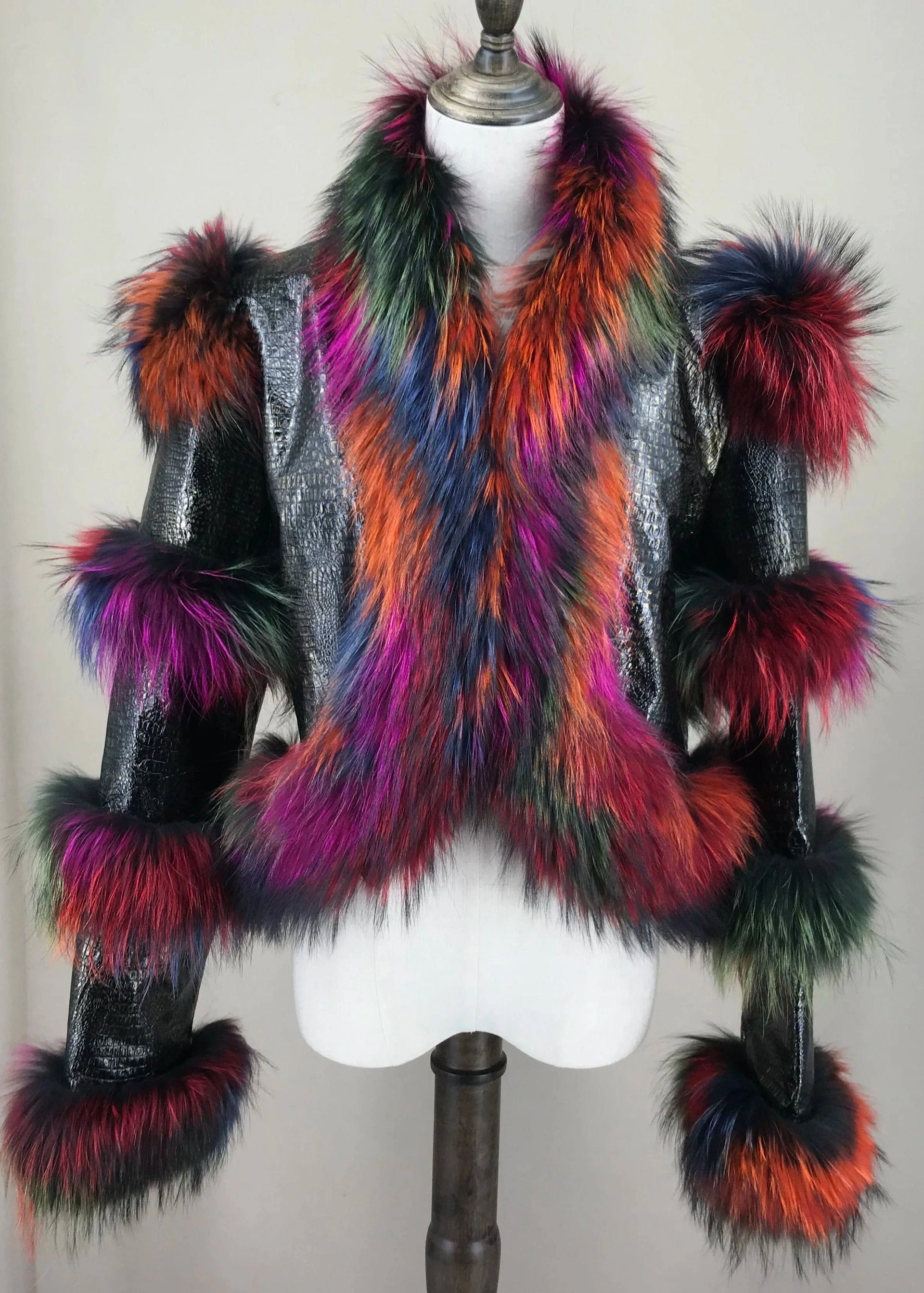 Mannequin wearing a colorful fur coat with a multicolored fur scarf against a plain background