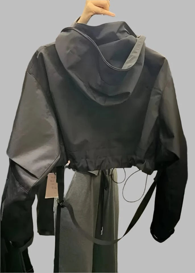 Black raincoat on a hanger in a store setting