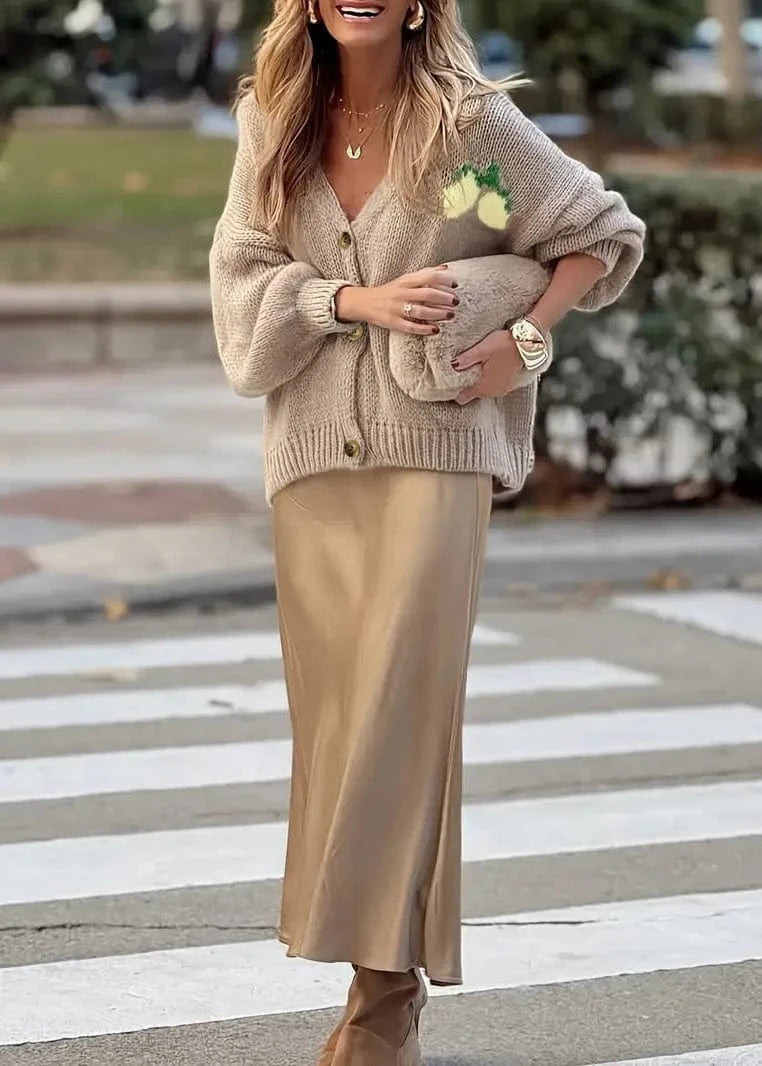 Woman in beige cardigan and skirt crossing a street