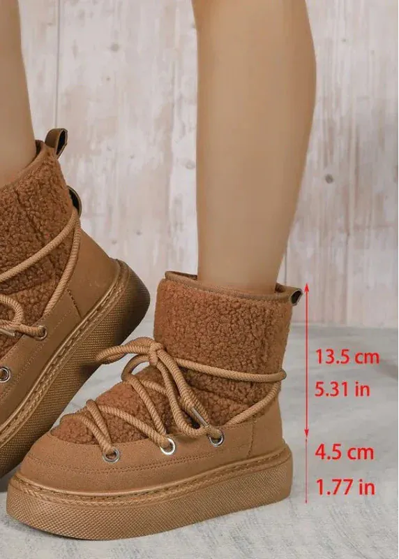 Brown winter boots with measurements on a light wooden floor background
