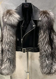 Black leather jacket with fur trim on a stand against a concrete wall.