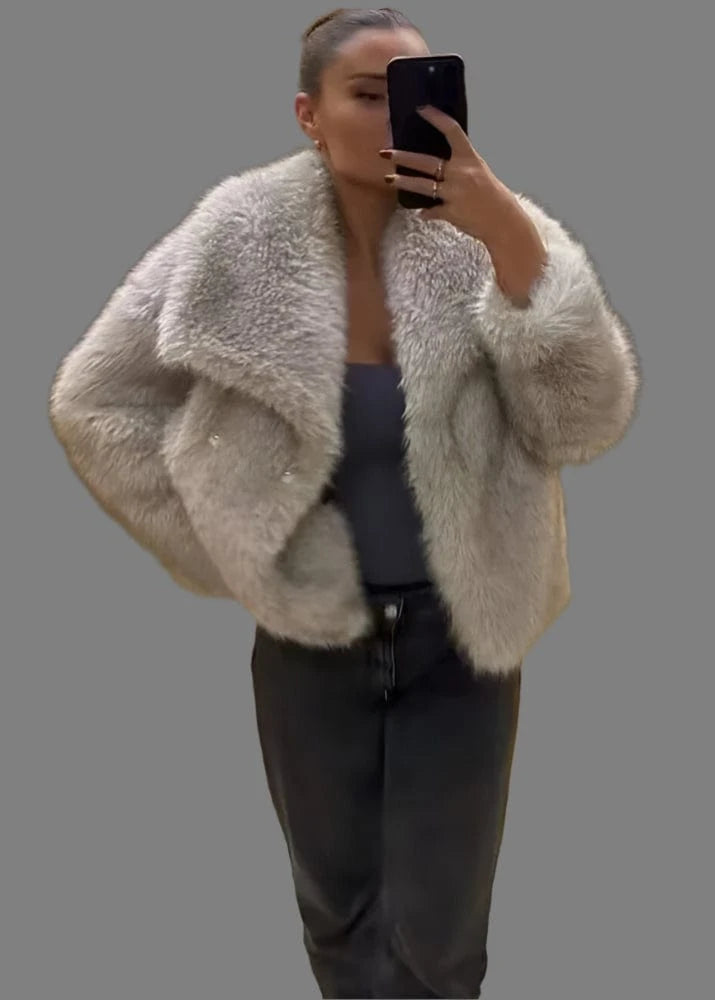 Person wearing a fluffy gray jacket taking a mirror selfie.