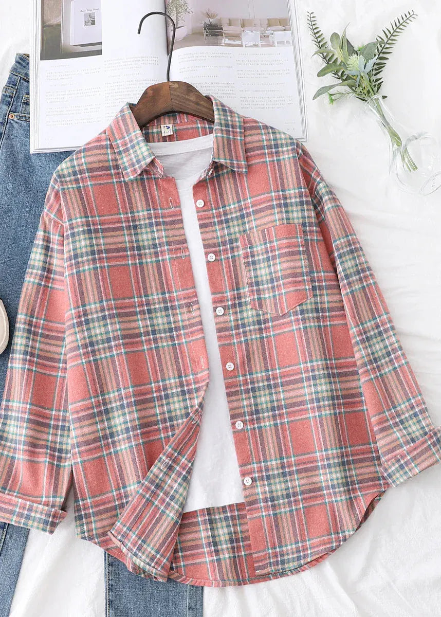Plaid shirt on a hanger with jeans and a plant in the background