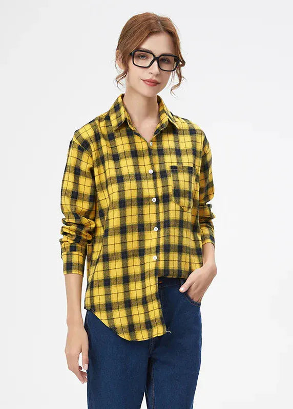 Woman wearing a yellow and black plaid shirt on a white background