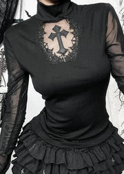 Black long-sleeve top with sheer sleeves and a decorative cross design, worn with a black skirt.