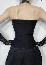 Person wearing a black strapless top and high-waisted pants with lace gloves on a white background