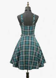 Green plaid dress on a mannequin against a white background
