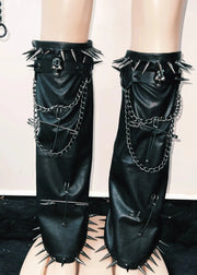 Black leather leg warmers with spikes and chains on a neutral background