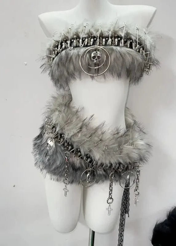 Mannequin wearing a decorative outfit with fur and chains on a white background