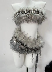Mannequin wearing a decorative outfit with fur and chains on a white background