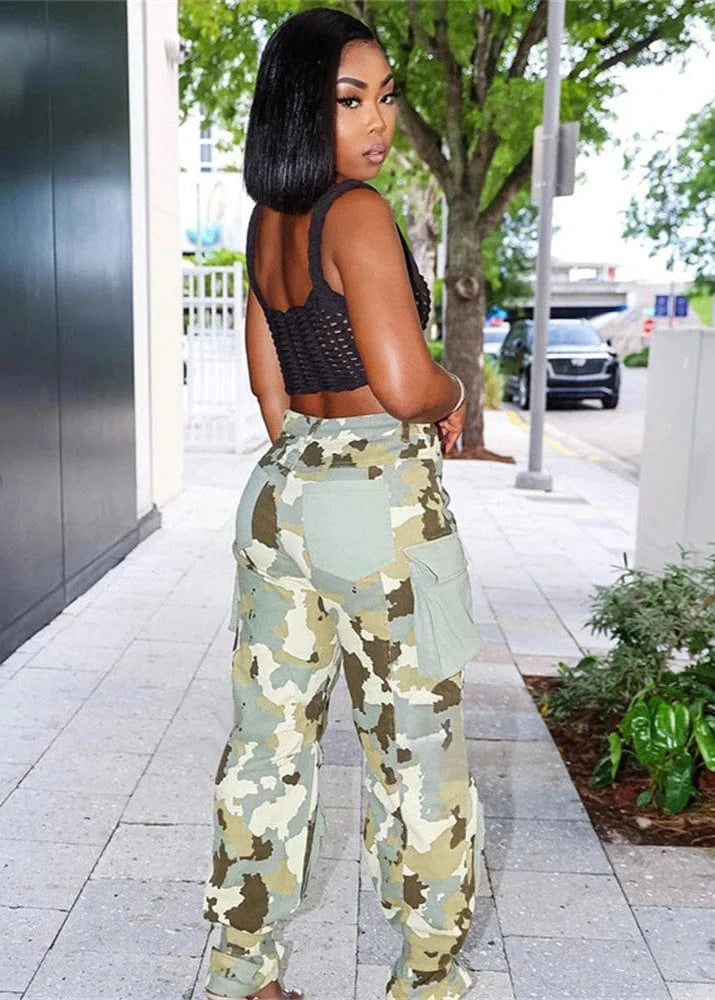 Woman wearing camouflage pants and a black top on a city street.