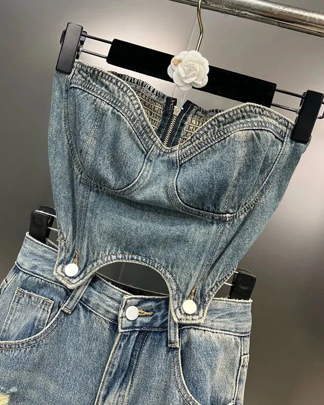 Denim overalls with a bralette on a hanger against a neutral background