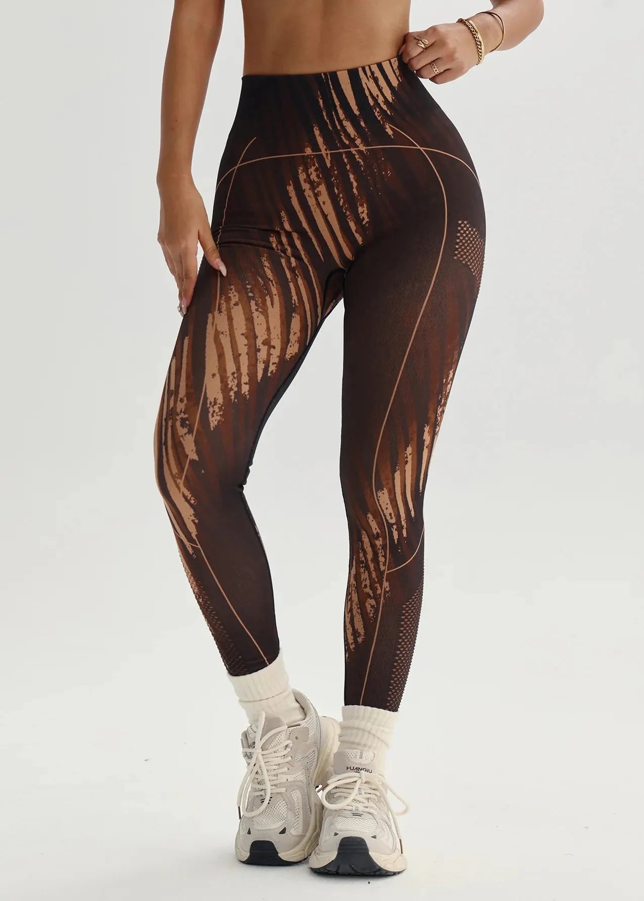 Person wearing brown patterned leggings on a white background