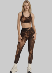 Woman wearing a brown patterned sports bra and leggings set on a gray background with 'arvin' branding.