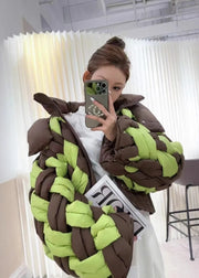 Person wearing a large, braided costume with brown and green colors in an indoor setting.