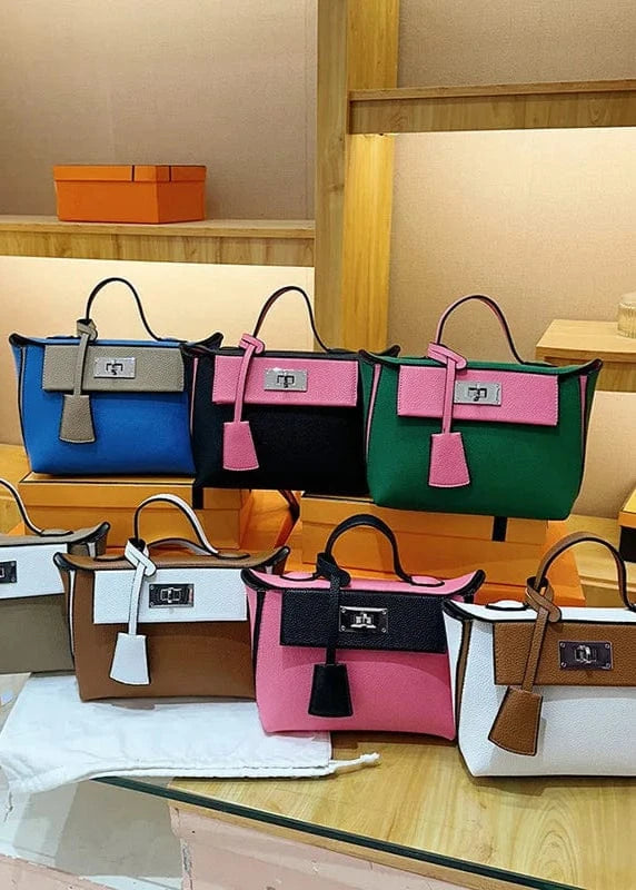 Collection of colorful handbags on a glass table with a wooden background