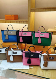 Collection of colorful handbags on a glass table with a wooden background