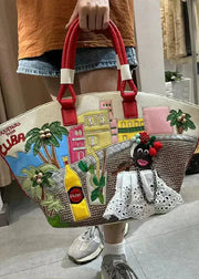 Person holding a colorful handbag with Cuban-themed design in an indoor setting.