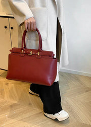 Person holding a red handbag on a wooden floor
