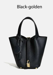 Black handbag with gold accents on a white background