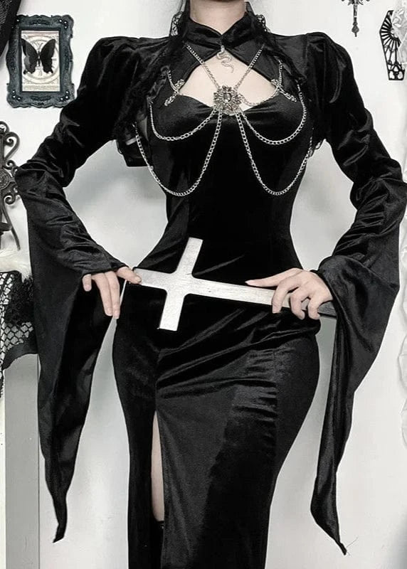 Person wearing a black gothic dress holding a sword in a decorative setting with crosses and spider webs.