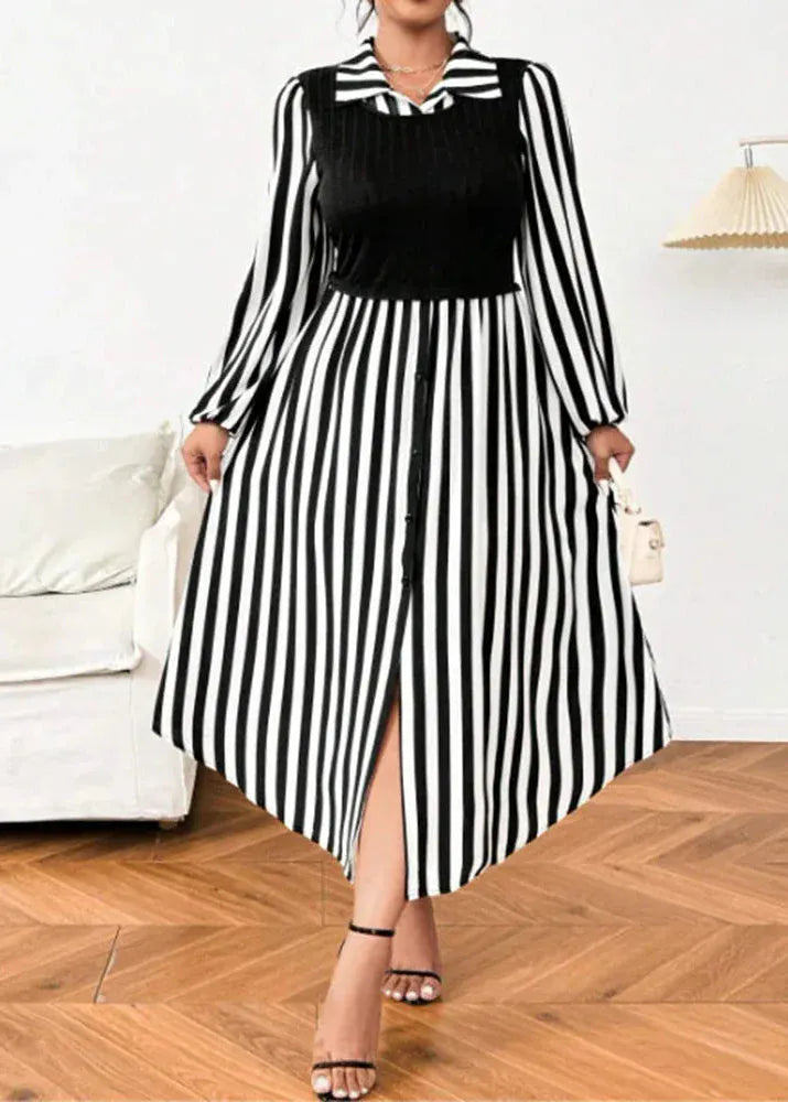 Woman wearing a black and white striped dress with a high slit, standing in a room with a white couch and wooden floor.