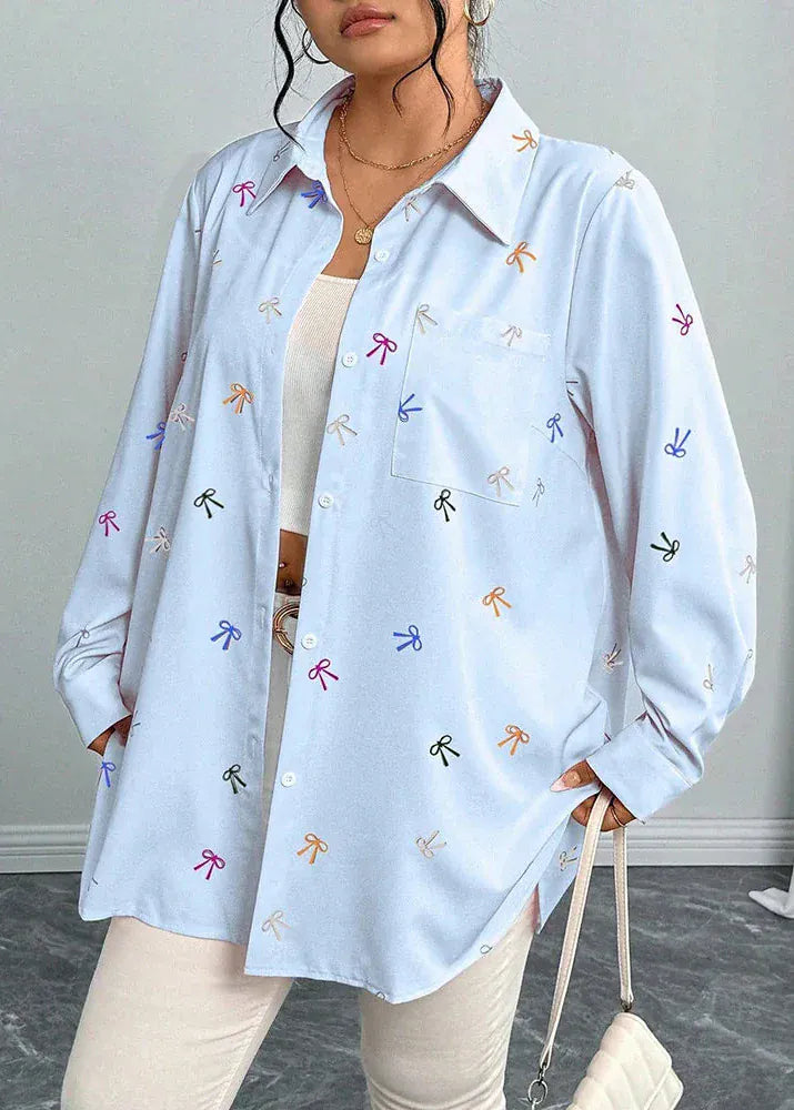 Light blue shirt with colorful bow patterns worn by a person on a neutral background