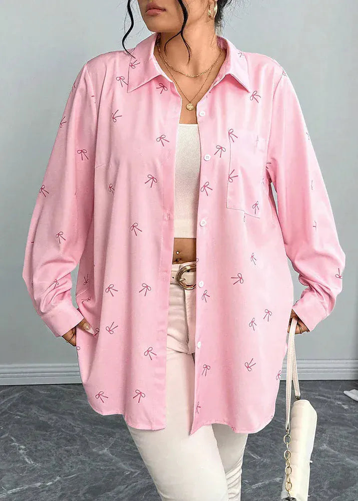 Person wearing a pink shirt with bow patterns on a neutral background