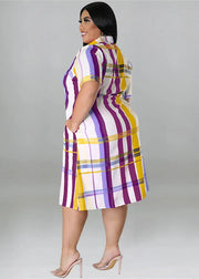 Woman wearing a colorful plaid dress against a gray background