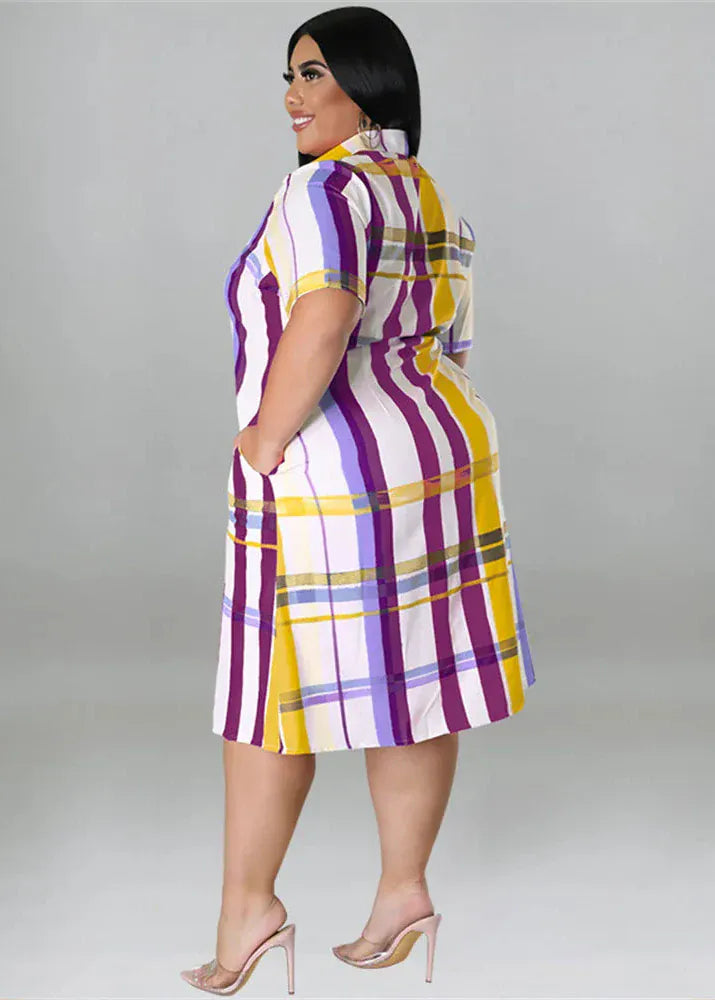 Woman wearing a colorful plaid dress against a gray background