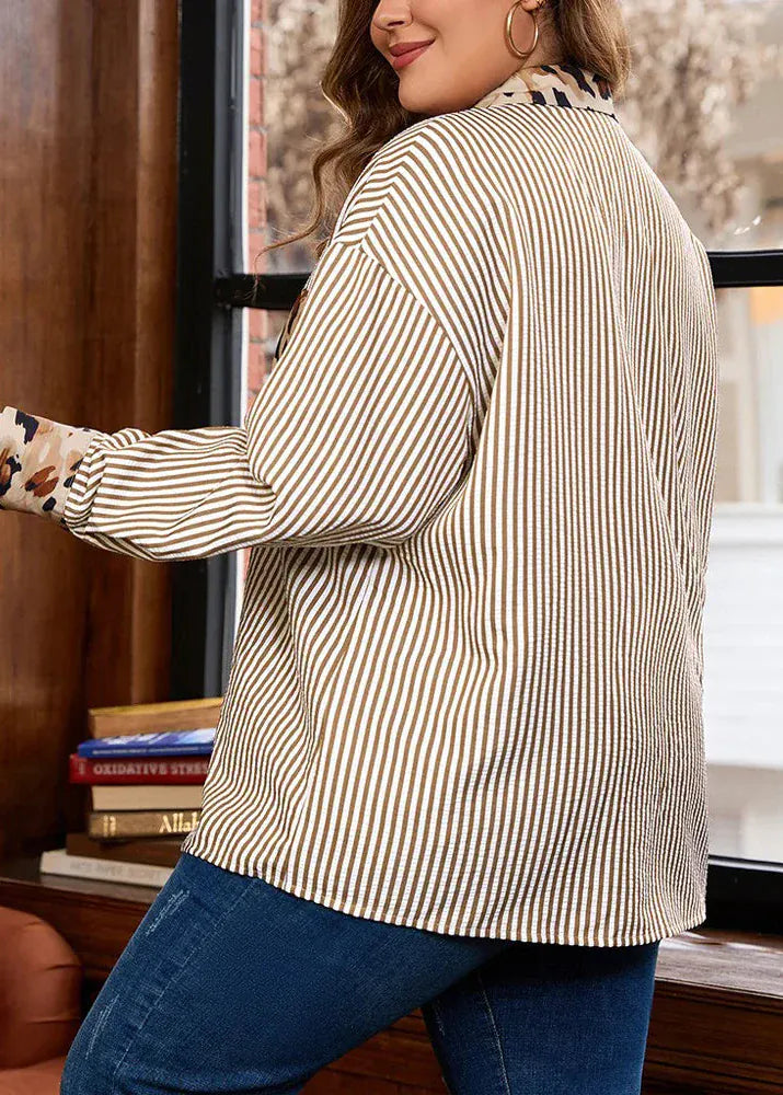 Woman wearing a striped shirt and blue jeans indoors.