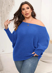 Woman wearing a blue off-shoulder sweater and jeans in a casual setting.