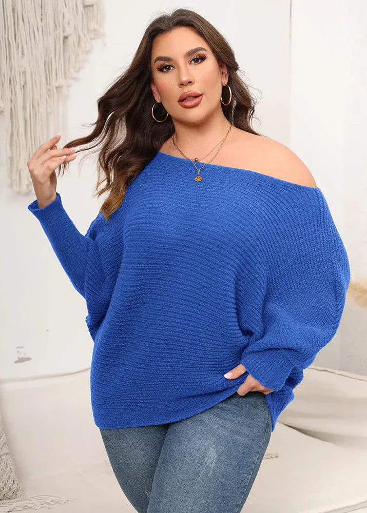 Woman wearing a blue off-shoulder sweater and jeans in a casual setting.