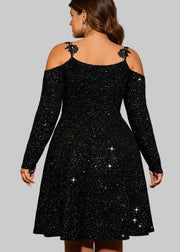 Woman wearing a black sparkly dress in an elegant room with candles and a chandelier.